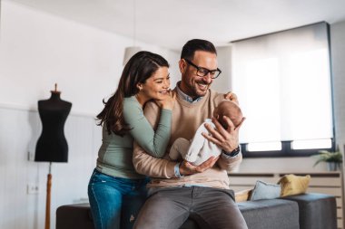 Aile, evlat edinme, bebek, ebeveynlik ve insan konsepti. Mutlu anne, yeni doğmuş bebeği olan baba.