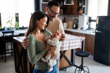 Barışçıl, genç, evli bir çift aile olmanın keyfini çıkarıyor, ebeveynler kucağında yeni doğmuş bir bebek, birbirlerine yakın duruyorlar. Ebeveynlik, doğum, ilişki kavramı