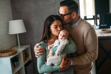 Gururlu anne ve baba yeni doğan kızlarına gülümsüyor. Evdeki oğullarına. Mutlu aile kavramı