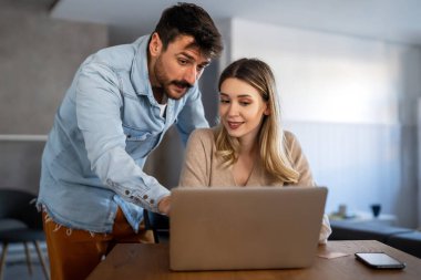 Ev ofisinde laptopa bakan gülümseyen bir çiftin portresi. İnsanlar teknoloji eğlence konsepti.