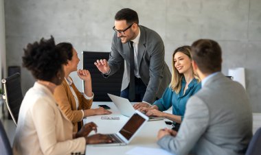 İşletme bürosundaki meslektaşlarıyla birlikte çalışırken analitik rapor sunan başarılı çoklu etnik çeşitlilikte iş adamları