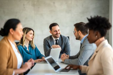 İşletme bürosundaki meslektaşlarıyla birlikte çalışırken analitik rapor sunan başarılı çoklu etnik çeşitlilikte iş adamları