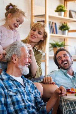 Neşeli, çoklu kuşak bir aile evde birlikte vakit geçirirken eğleniyor. İnsanların mutluluk kavramı.