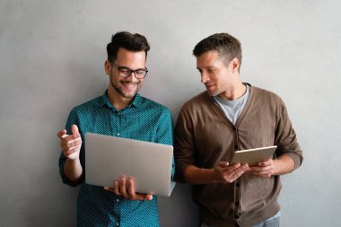 Genç yönetici ofiste bilgisayar kullanırken tecrübeli meslektaşlarıyla konuşuyor. Meslektaşlar iş, mali ve pazarlama projelerini tartışırlar. Uzmanlar çeşitli başlangıç takımlarında çalışırlar.