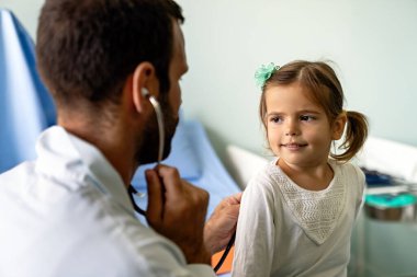 Hastanede steteskopla küçük kızı muayene eden genç bir doktor. Sağlık, çocuk, çocuk doktoru konsepti.