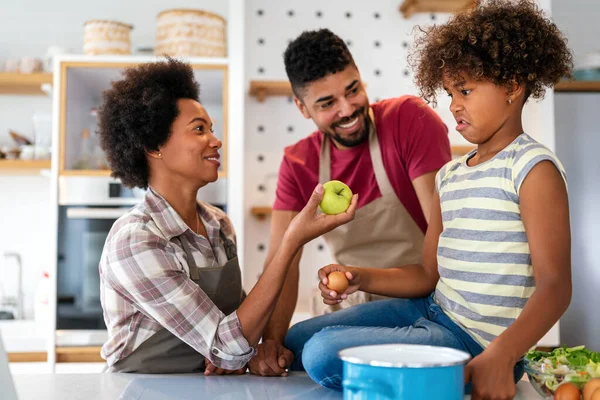 快乐的年轻非洲裔美国家庭带着孩子在家里做饭玩得很开心 快乐的微笑的父母和孩子一起在厨房玩周末游戏 — 图库照片
