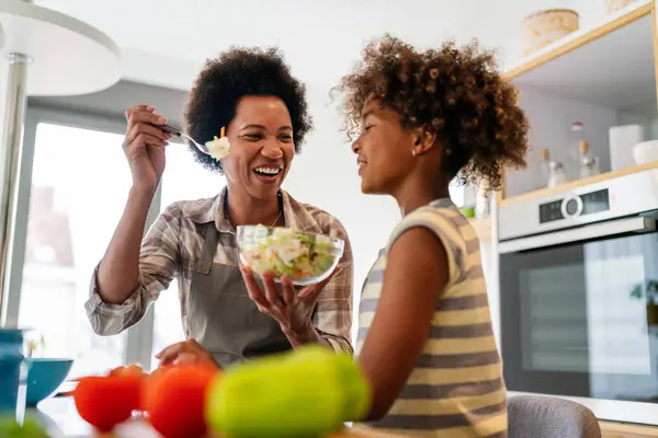Portrait of happy black woman and her cute preteen daughter having fun together at home, Happy african american family bonding, embracing and smiling