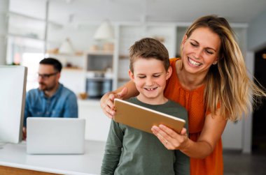 Anne ve çocuğun e-öğrenim için dijital tablet kullanan portresi. Eğitimde evde eğitim veren dijital cihaz çocuk kavramı.