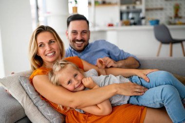 Mutlu genç aile evde eğleniyor. Ebeveynler, çocuklar mutluluk kavramını sever.