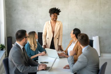 İşletme bürosundaki meslektaşlarıyla birlikte çalışırken analitik rapor sunan başarılı çoklu etnik çeşitlilikte iş adamları