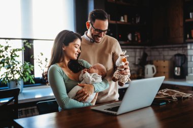 Evde dizüstü bilgisayarı olan, çocuklu neşeli bir aile. Aile mutluluk teknolojisi kavramı.