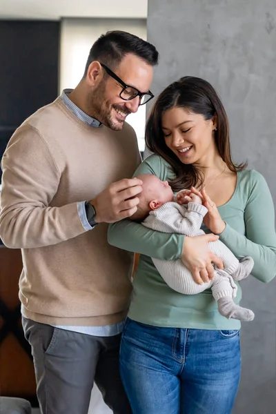 Family, adoption, baby, parenthood and people concept. Happy mother, father with newborn baby at home