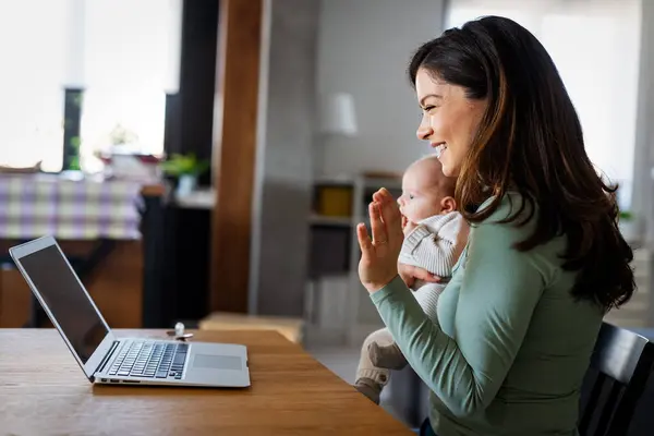 Family, technology and motherhood concept. Happy smiling young mother with baby. Video communication. Stay at home.