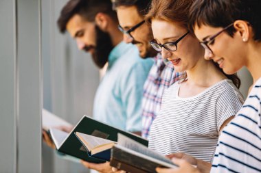 Öğrenciler kütüphanede okuyor. Gençler birlikte zaman geçirip birlikte öğreniyor..