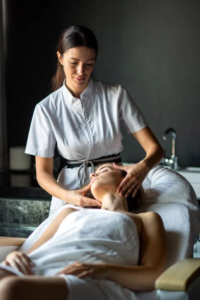 Beautiful happy relaxed woman enjoying professional wellness massage in spa salon. Wellness people relax body care concept