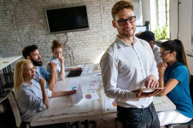 Çeşitli çalışanlar, beyin fırtınası sırasında ofiste toplanarak yeni projeleri için yeni fikirleri tartıştılar. Çok ırklı iş arkadaşları toplantı odasında toplanıp toplantıda fikir alışverişinde bulundular..