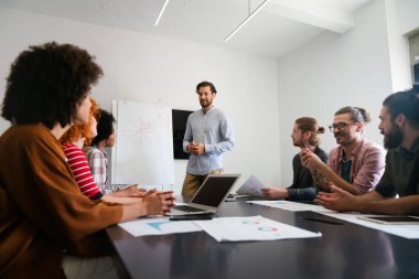 Ofisteki çeşitli çalışanlar yeni projeleri için yeni fikirleri tartışırken beyin fırtınası sırasında eğleniyorlar. Yönetim kurulundaki çok ırklı iş arkadaşları brifingde fikir alışverişinde bulundular..