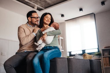Aile sevgisi bebek konsepti. Genç ebeveynler yeni doğan çocukla mutlu anlar geçirirler.