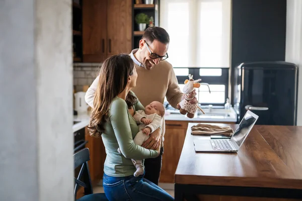 Happy young family with infant newborn baby having video call online conference conversation with relatives doctor pediatrician, having consultation remotely, communicating with friends