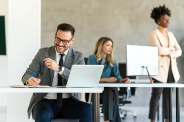 Ofiste dizüstü bilgisayar kullanan genç bir işadamı. Yönetici başarılı finansal fikirleri düşünür. Şirket için problem çözme çözümleri bulmak.