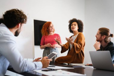 Mutlu, genç, Afro-Amerikan bayan liderleri, dost canlısı çeşitli meslektaşlarıyla toplantı yapıyor. Modern ofis odasında toplanıp proje fikirlerini tartışıyor ya da strateji geliştiriyor..