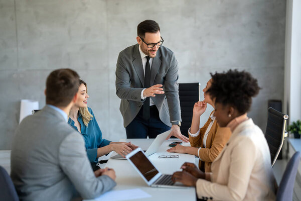 CEO businesswoman leader with diverse coworkers team, executive managers group at meeting. Multicultural professional businesspeople working together on research plan in boardroom.