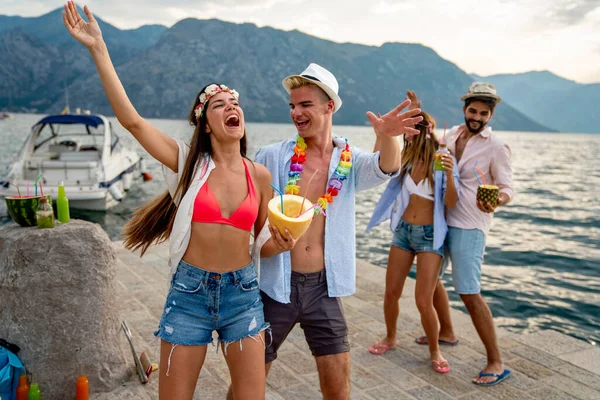 Group of friends having Hawaiian party on summer vacation. People fun travel sea concept.