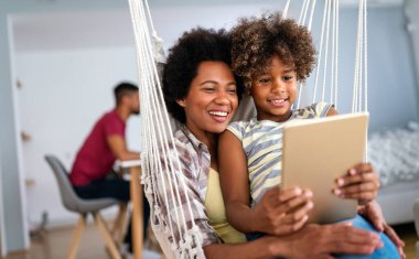 Çocuklu mutlu Afro-Amerikan anne portresi eğitim, eğlence ve oyun için dijital tablet kullanıyor. Teknoloji insanları kavramı