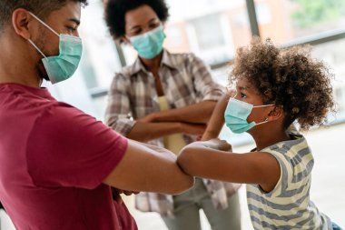 Koronavirüs salgınının ortasında koruyucu tıbbi maskeli Afrikalı Amerikalı genç aile.