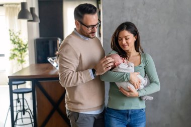 Gururlu anne ve baba yeni doğan kızlarına gülümsüyor. Evdeki oğullarına. Mutlu aile kavramı