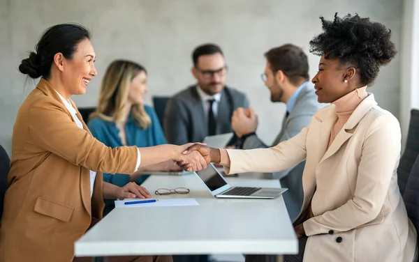 Young business people shaking hands in office. Handshake, finishing successful meeting. Business etiquette, congratulation meeting job interview new business startup employee teamwork trust