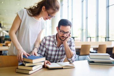 Bir kolej kütüphanesinde birlikte çalışıp çalışan bir grup başarılı öğrenci. Eğitim insanları öğrenme kavramı.