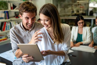 Gülümseyen çeşitli meslektaşlar toplantı odasında toplanmış mali istatistikleri tartışıyorlar. Mutlu çok ırklı iş arkadaşları ofis toplantılarında işbirliği yaparken eğleniyorlar. Takım çalışması konsepti.