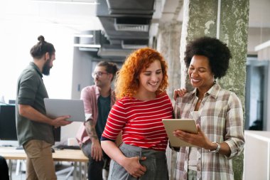 Mutlu iş arkadaşları, modern ofisteki iş arkadaşlarıyla iş başında ve toplantıdalar. Proje fikirlerini tartışmak veya strateji geliştirmek.