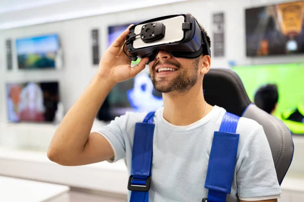 Portrait of young man using virtual reality headset at exhibition, show. VR technology simulation concept