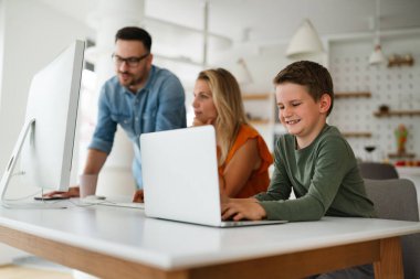 Çocukla evde çalışmak. Çocuk dizüstü bilgisayarla oynarken iş yapan genç ebeveynler.