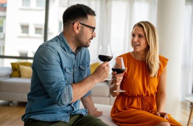 Romantik bir buluşma yaşayan ve şarap içen genç ve mutlu bir çift. Çiftler aşk konseptini sever.