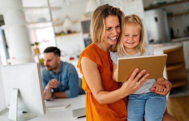 Dijital cihaz teknolojisi aile çevrimiçi eğitim kavramı. Evde dijital cihazları olan mutlu genç bir aile..