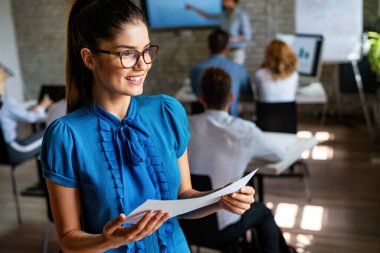Takım toplantısında gülümseyen, kendine güvenen genç bir iş kadınının portresi. Yönetim kurulundaki meslektaşlarıyla birlikte kendine güvenen bir iş kadınının portresi..