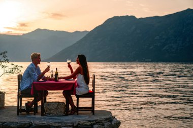 Balayı çifti yaz tatilinde tropik bir plajda özel, romantik bir akşam yemeği yiyorlar..