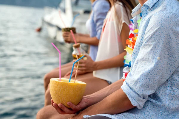 Group of happy friends having fun with tropical cocktails on beach party. Travel and summer vacation concept.