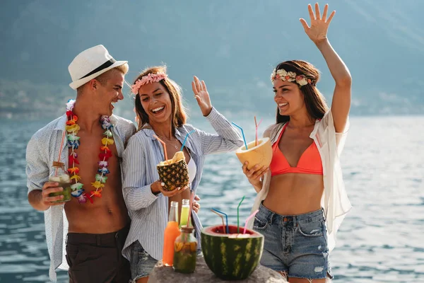 Group of multiethnic friends enjoying Hawaiian party on summer vacation. Summertime vibes, travel concept.