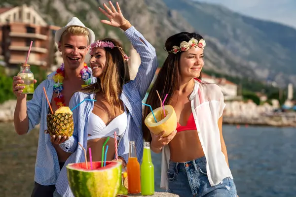 Group of multiethnic friends enjoying Hawaiian party on summer vacation. Summertime vibes, travel concept.