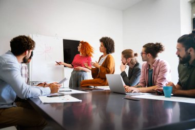 İş arkadaşlarıyla yaptığı bir toplantıda genç bir iş kadını bir tartışma yürütüyor. Bir grup farklı iş adamı modern bir iş yerinde birlikte çalışıyor. Bir proje üzerinde çalışan iş arkadaşları.