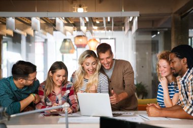 Gülümseyen çeşitli meslektaşlar toplantı odasında toplanmış mali istatistikleri tartışıyorlar. Mutlu çok ırklı iş arkadaşları ofis toplantılarında işbirliği yaparken eğleniyorlar. Takım çalışması konsepti.