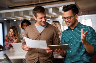 Gülümseyen çeşitli meslektaşlar toplantı odasında toplanmış mali istatistikleri tartışıyorlar. Mutlu çok ırklı iş arkadaşları ofis toplantılarında işbirliği yaparken eğleniyorlar. Takım çalışması konsepti.