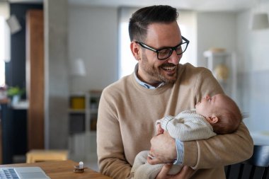 Yeni doğmuş bebeğini kucaklayan ve öpen bir babanın portresi. Erkek ebeveyn çocuğunu tutuyor. Otantik yaşam tarzı dokunaklı bir an. Bekar baba aile hayatı konsepti.