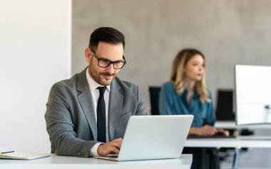 Ofiste dizüstü bilgisayar kullanan genç bir işadamı. Yönetici başarılı finansal fikirleri düşünür. Şirket için problem çözme çözümleri bulmak.