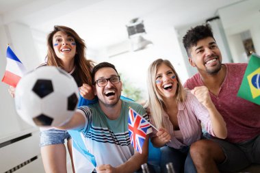 Futbol fanatikleri duygusal olarak oturma odasında maç izleyip çığlık atıyorlar.