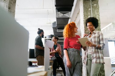 Çeşitli mutlu çalışanlar dijital cihazla raporları analiz ediyor, pazarlama, istatistiksel verileri tartışıyor, konuşuyor, beyin fırtınası yapıyor. İş toplantısı konsepti